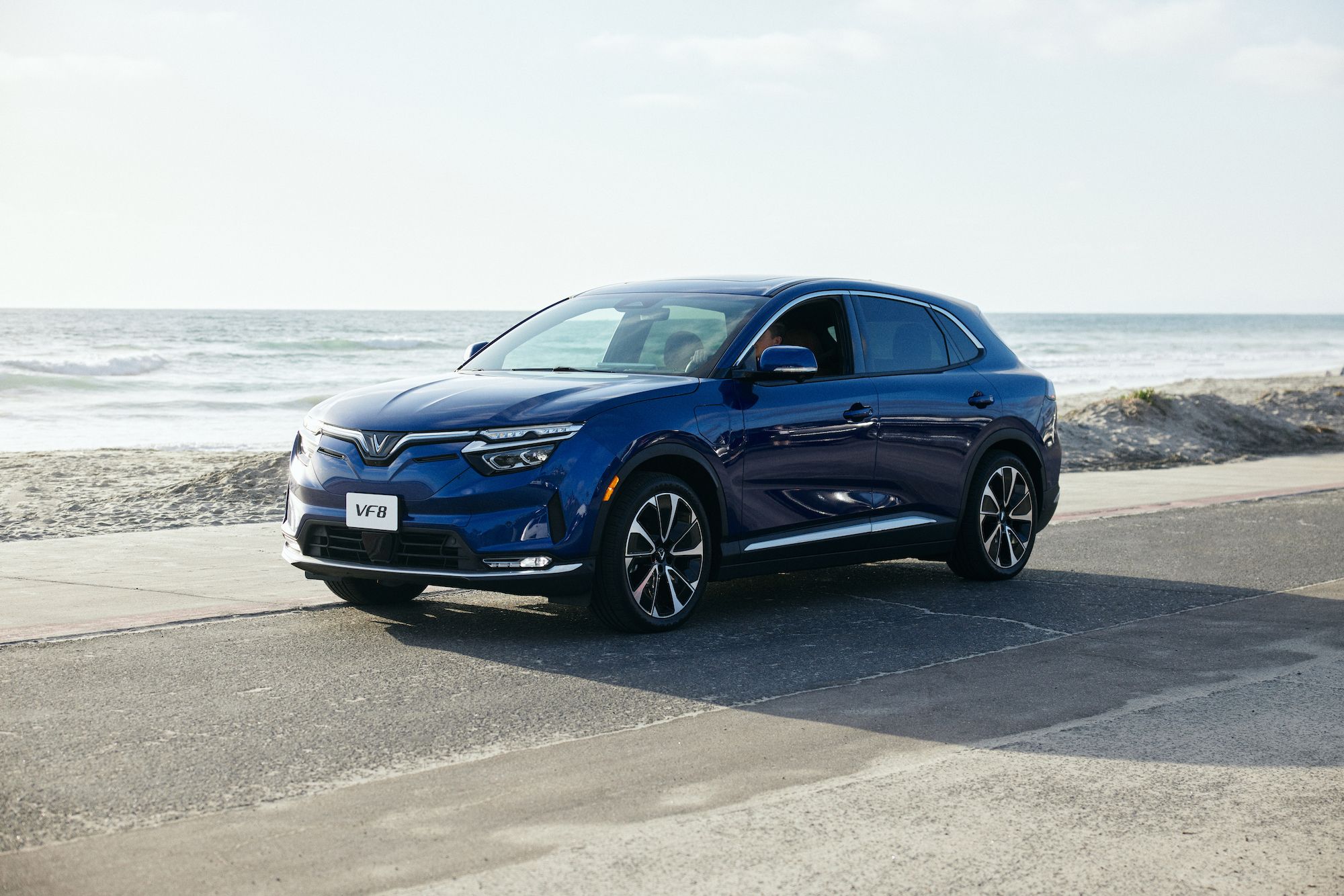 2024 VinFast VF8 in blue driving along the coast on the sound