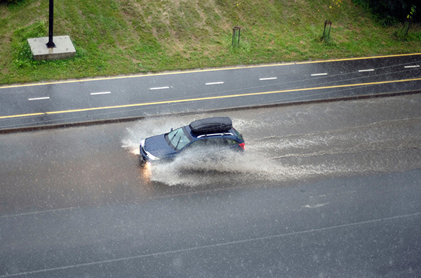 Car driving through deep water on the road